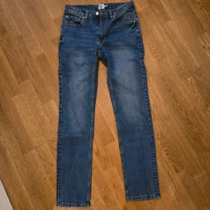 Blå jeansbyxor - Säljer ett par klassiska blå jeansbyxor från märket lager 157 De har en straight passform och är i bra skick. Perfekta för vardagsbruk med en snygg tvätt och traditionell design. Midwaist och bekväma att bära hela dagen.