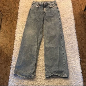 Blå jeans från Never Denim 28x32 - Säljer ett par snygga blå jeans från Never Denim by Bik Bok. De har en loose passform och är tillverkade i 100% bomull. Perfekta för en avslappnad stil och passar bra till både vardag och fest. De är i bra skick och redo för en ny ägare!