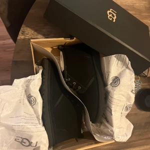 Svarta Neumel Boots från UGG - ⭐️ Säljer ett par snygga svarta mocka boots från UGG i storlek herr 43. ⭐️De är helt oanvända! Endast provade och kommer i originalförpackning. ⭐️ Perfekta för höst och vinter med sin varma och bekväma design. ⭐️ Köpta för 1850 på Miinto