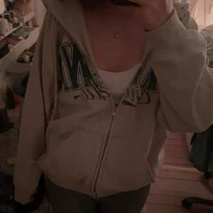 Beige hoodie från H&M Divided - Säljer en beige hoodie från H&M Divided i storlek S pga att den inte används💕 Den har en dragkedja framtill och en mysig huva. Den har ett tryck i grönt på framsidan där det står ”Ottawa, Canada”. Jättebra skick. 