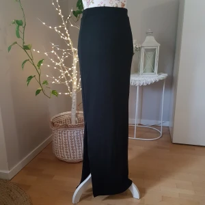 NY långkjol/maxikjol från VILA - Ny/oanvänd! Tjockare, småglansigt, ribbat och stretchigt tyg. Dragkedjeslits på var sida. Smickrande passform! ~ STOR rensning & klänningsbonanza i min shop ~ Välj 5 för 100kr oavsett pris, skicka medd/lämna som prisförslag (gäller där det står) ~