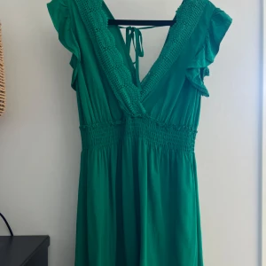 Grön klänning från N.EVERY DAY - Säljer en superfin grön klänning från N.EVERY DAY med knytning i ryggen. Perfekt som sommarklänning eller för semestern! 💚 Det står M/L men den är mer åt S hållet i storlek. Klippt av längst ned då den var hellång förut, men trivs bättre i kort🤗