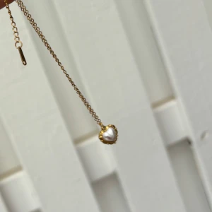 Hjärtformat Vintage  Halsband - Charmigt choker-halsband i rostfritt stål med ett hjärtformat vintage mönster och snäckskalsdetaljer.