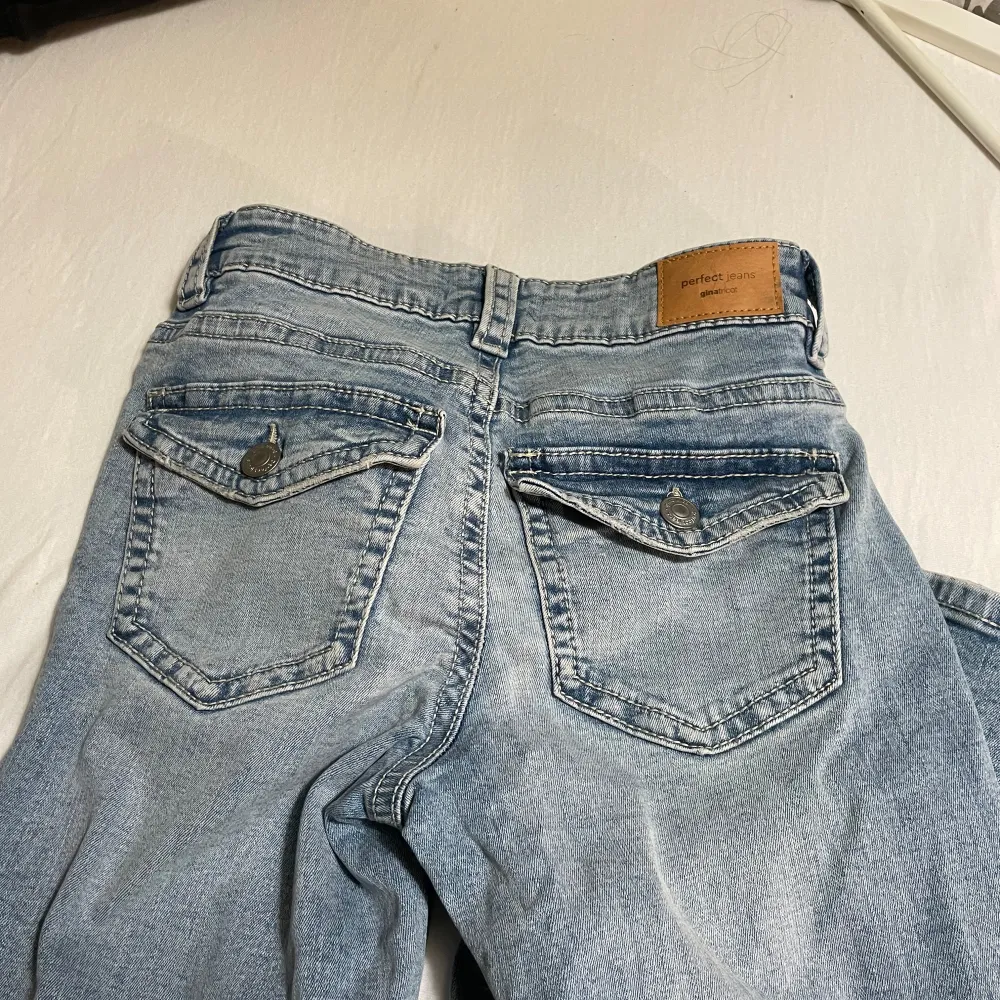 Den har fickor där bak. Jeansen är blåa och low waist. Jeans & Byxor.