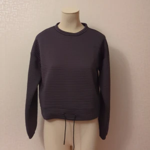 Hoddie - En mjuk hoddie med snörning till midjan. Den är använd sparsamt och är i fint skick. O knöten är den från halsen  47cm