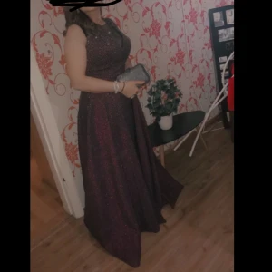 Klänning - En riktigt fin klänning som jag säljer åt min mamma, klänningen är i vinröd/lila och svart färg som säljs för 1000 Vid frågor tveka inte att skriva!!!