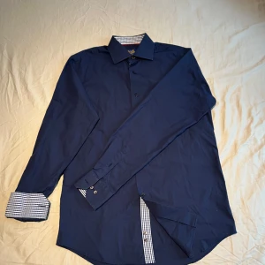 John Henric Skjorta - Snygg John Henric skjorta i storlek 16/40 (M). Väldigt bra skick. Nypris 999 kr. 