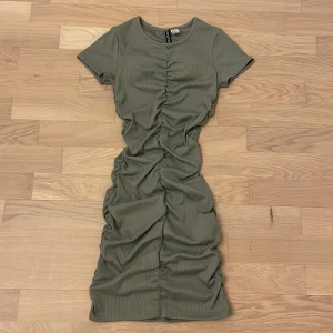 Grön tajt klänning  - Em snygg grön klänning med tajt och fin pasform. Fin söm i mitten av klänningen som ger en skrunch effekt!😊💕 Mycket bra skick!