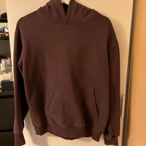 Brun hoodie - Säljer en mysig brun hoodie i bra skick. Perfekt för höst och vinter med sin varma och bekväma design. Den har en klassisk känguruficka framtill och en stor huva för extra komfort. Passar perfekt för en avslappnad stil!