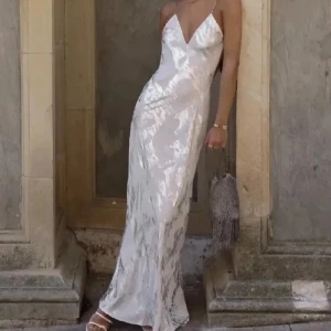 Silver/vit slutsåld maxiklänning - Säljer min superfina examensklänning som är slutsåld, i bra skick från Zara. Har sytt upp axelbanden som var för långa men det går att ta bort om man vill