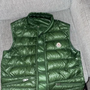 Moncler gui väst - Hej! Säljer nu min skitsnygga väst från moncler, den är i fint skick, 8/10. Endast lagningar på ryggen gjorda av självaste moncler. Strl 3 motsvarar M. Skriv om ni har något fundering