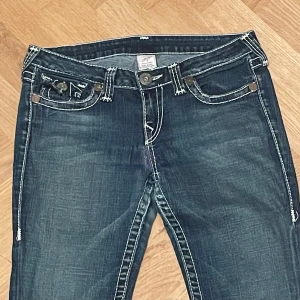 Vintage True Religion jeans #31 - Made in USA vintage True Religion jeans. Mörkblå denim med vita sömmar. Bootcut och midwaist. Mått Midja ca. 41/82cm Inre benlängd ca.70cm Yttre benlängd ca.95cm Vidd nedtill ca. 23cm