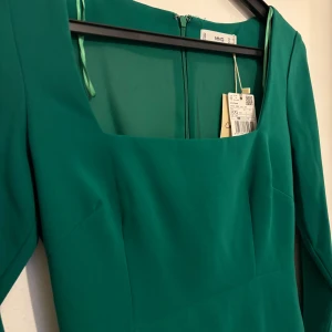 Kort klänning  - En grön , kort klänning som slutar i mitten av låret . Kort i armbarna också . Aldrig använd utan helt ny med lappar o allt  Klassade ny 799