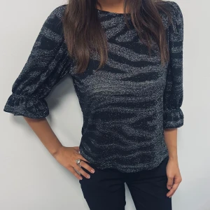 Festtopp - En classy glitterblus i zebra-mönster som funkar för uppklädd vardagslook men också perfekt för party!🥳  Pris kan diskuteras
