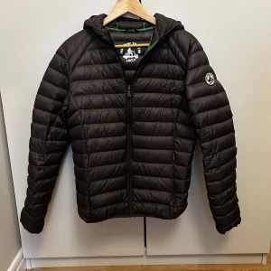 Brun dunjacka från Jott - Säljer en snygg och varm brun dunjacka från Jott. Jackan har en dragkedja framtill och är långärmad med en mysig huva. Perfekt för kyliga höst- och vinterdagar. Den är i bra skick och redo för nya äventyr!