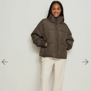 Brun pufferjacka - Säljer en snygg brun pufferjacka i oversized stil. Jackan har en hög krage och dragkedja framtill, perfekt för kalla dagar. Den är långärmad och har en quiltad design som ger extra värme och stil. Perfekt för höst och vinter!