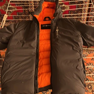 Grå jacka från Sail Racing - Snygg grå Sail Racing-jacka, stilren och funktionell. Lätt använt, men ett litet hål – perfekt för den som vill ha en bra deal. Storlek M.