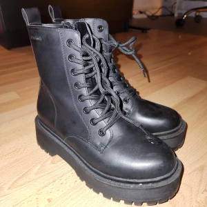 Svarta ATTITUDE boots med snörning - Säljer ett par svarta boots med snörning. De har även dragkedja på ena sidan. De har en rejäl sula och är perfekta för höst och vinter. Skorna är i bra skick och passar både till vardags och lite tuffare outfits.