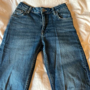 Blå jeansbyxor - Säljer ett par low waist blåa jeansbyxor i bra skick. De har en normal passform och är perfekta för vardagsbruk. 