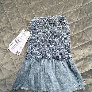 Blå jeans topp från Gina Tricot - Superfin blå jeanstopp från Gina Tricot i storlek S. Hade viljat den satt något tajtare 