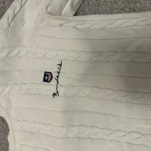 Vit stickad tröja från Bondelid - Säljer en superfin vit stickad tröja från Bondelid i storlek XS. Den har ett klassiskt flätmönster och broderad logga på bröstet. Perfekt för kyliga dagar och passar både till vardags och lite finare tillfällen. Tröjan är i mycket bra skick och redo för en ny ägare! 🤍