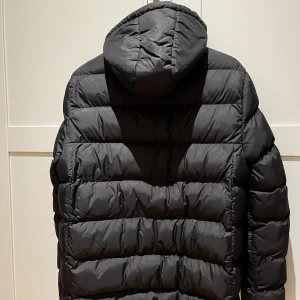 Svart dunjacka från Vinsun Polo Club - Säljer en svart dunjacka från Vinsun Polo Club i mycket bra skick. Jackan har en huva och dragkedja framtill. Den är dekorerad med broderade detaljer och märkeslogga på bröstet. Perfekt för kalla vinterdagar! Stl 170