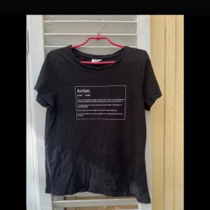 Svart t-shirt med texttryck S/M artist  - En svart t-shirt med artist-tryck. I utmärkt skick. Passar en st S/M.  Hör av dig om du har någon fundering och titta gärna in mina andra annonser!