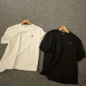 Svart och vit t-shirt med röd broderad detalj - Två snygga t-shirts i svart och vit från ami, bättre pris vid snabb affär 