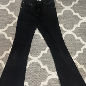 Svarta bootcut jeans - Säljer ett par svarta bootcut jeans i bra skick. De har en klassisk femficksdesign och är perfekta för både vardag och fest. Passar bra till höst- och vintergarderoben. Dragkedja och knapp framtill för enkel stängning.