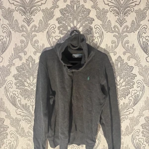 Mörkgrå tröja från Polo Ralph Lauren - Säljer en snygg mörkgrå tröja från Polo Ralph Lauren i storlek S. Tröjan har en liten grön logga på bröstet och är perfekt för både höst och vinter. Den är i bra skick och supermjuk, perfekt för en casual look. Passar både till jeans och chinos! Detta är en turtle neck pris går att diskuteras