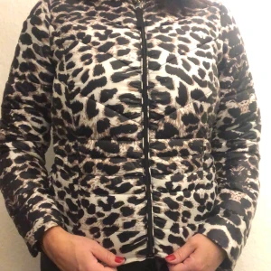 Leopardmönstrad pufferjacka - Säljer en supercool leopardmönstrad pufferjacka med dragkedja. Jackan är perfekt för höst och vinter och har långa ärmar. Den är i mycket bra skick och ger en trendig look. Perfekt för dig som vill sticka ut i mängden!