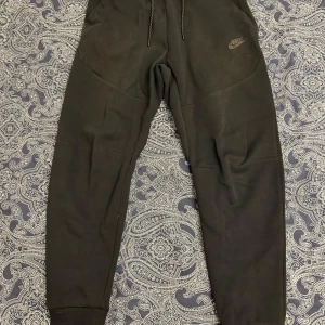 Nike tech byxor  - Säljer nu dessa svarta Nike tech byxor i storlek S. Bra skick. Nypris 1000kr