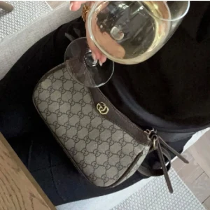 Väska - Snygg och stilren väska i beige och brun med gulddetalj. Köpt second hand.