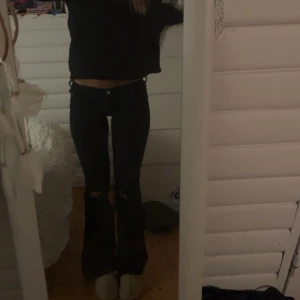 Svarta lågmidjade bootcut jeans med hål - Säljer dessa svarta bootcut jeans i bra skick💕Har sytt om de till lågmidjade men skulle säga att de är åt midwaist hållet. Jeansen har nån mindre defekt (smuts som inte går bort) men som knappt syns. Kom gärna med prisförslag🥰