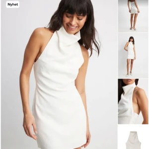 Vit axelbandslös klänning - Snygg vit axelbandslös klänning i ett stilrent och modernt snitt. Perfekt för festliga tillfällen med sin eleganta design och korta längd. Materialet ser ut att vara av hög kvalitet och ger en lyxig känsla. Nytt skick och redo att bäras på nästa event! Perfekt till student