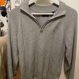 Grå Halv zip Gant tröja XS - Säljer en stilren grå halvzip tröja från Gant i mycket bra skick. Den har en dragkedja framtill. Perfekt för både höst och vinter. Det står storlek 146/152 men beroende på kroppsform och liknande tror jag att sen passar mellan 145-160. Mvh Hannes