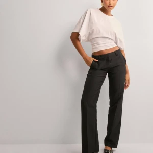 Low waist svarta kostymbyxor - Snygga svarta kostymbyxor i normal passform. De har en klassisk design med raka ben och låg midja, perfekt för både kontoret, festliga  och vardags tillfällen. Byxorna är i nytt skick. 