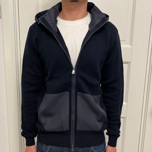 Cardigan/Jacka - Otroligt fet cardigan! Sprillans ny och oanvänd med lapparna kvar. Avtagbar dunluva, vilket gör att den passar till olika tillfällen. Storlek M. Nypris ca. 1700kr.  Hör av dig vid frågor/funderingar  