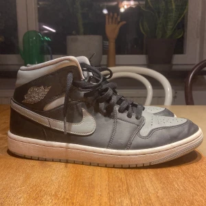 Nike Air Jordans i svart och grått - Säljer ett par Nike Air Jordan 1s i svart och grått. Skorna har en klassisk hög modell med snörning och är i bra skick. Perfekta för både vardag och festliga tillfällen. Storlek herr 41. Passa på att köpa dessa ikoniska sneakers! (Inga defekter) Pris är ej hugget i sten och kan diskuteras.