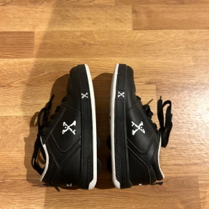 Svarta sneakers med hjul - Coola svarta sneakers med inbyggda hjul i sulan. Perfekta för att rulla runt med stil! Skorna har vita detaljer och snörning för en säker passform. De är i bra skick och redo för nya äventyr.