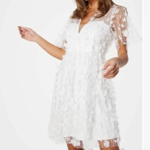 Vit blommig klänning med spetsdetaljer - Säljer min superfina studentklänning. Använt en gång och är i fint skick. Klänningen är i storlek 36, och är helt slutsåld. Perfekt inför student eller till midsommar🌸