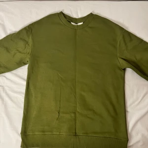 Olivgrön tröja - Säljer en olivgrön tröja från H&M i storlek M. Tröjan är i bra skick och har en normal passform med långa ärmar. Perfekt för höst och vår, och den är gjord av mjukt bomullsmaterial. Enkel och stilren design som passar till det mesta.