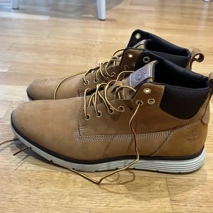 Bruna kängor från Timberland - Säljer ett par snygga bruna kängor från Timberland i mycket bra skick, endaste kvädna vid ett tillfälle. De är gjorda i skinn med snörning och har en robust sula som passar perfekt för höst och vinter. Perfekta för både stad och natur!