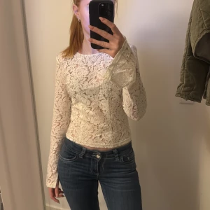 Vit spetsblus - Säljer en superfin vit spetsblus med långa ärmar. Perfekt för både vardag och fest! Blusen har en tight passform. Med en öppning i ryggen och slits i båda armarna😊☺️