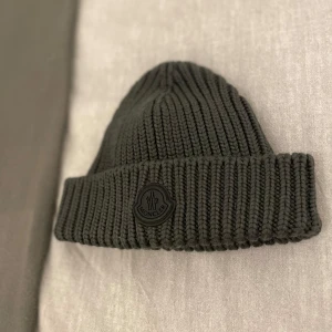 Moncler mössa (nyaste kollektionen) - Snyggaste och trendigaste Moncler mössan från nyaste kollektionen med perfekt passform och väldigt varm och skön att ha på sig, perfekt nu till vinter! 🥶 Storlek är one size, den är i nyskick, endast använd vid 2-3 tillfällen, säljes för 2499kr, köpt för 3500kr. Länk till mössan: https://www.ssense.com/en-dk/men/product/moncler/grey-knit-wool-beanie/7204821