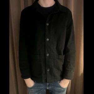 Svart overshirt med knappar från Oscar Jacobson - Säljer en stilren svart overshirt i mycket bra skick. Den har långa ärmar och knappar framtill. Perfekt för höst och vår, och funkar både till vardags och lite finare tillfällen. Materialet känns mjukt och bekvämt. Passar bra över en t-shirt eller tunn tröja. Skick 9/10 mycket sparsamt använd. Nypris 4000. Tveka inte på att höra av dig vid frågor/intresse💫