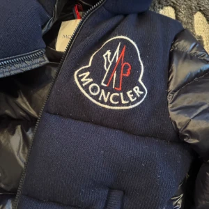 Svart Moncler dunjacka - Moncler, GIUBBOTTO PALISSER JACKET Strl: 14 år (motsvarar dam: XS eller herr: S) Använd en säsong. Väldigt fin och välbevarad. Pris vid inköp: 12 900:- 