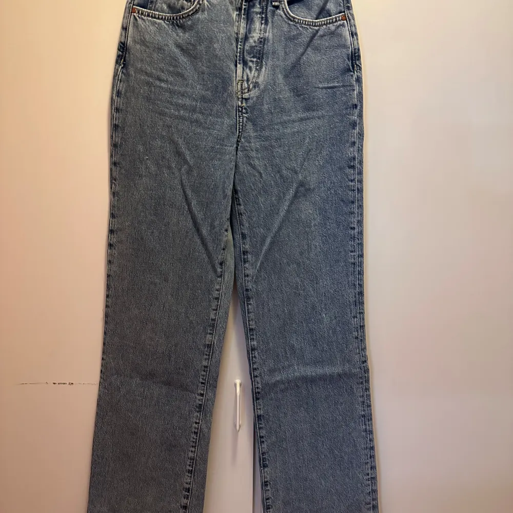 Säljer ett par blåa raka jeans från bikbok då jag inte använder dom längre, dom är använda men inga tydliga tecken på användning. Färgen är lite ljusare i verkligheten då ljuset bilden är tagen i är dåligt och får dom att se lite ojämna ut. Jeans & Byxor.