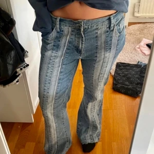 Unika lågmidjade jeans med ränder - Säljer ett par coola jeans med unika ränder framtill. De är i en klassisk blå jeansfärg och har en bootcut-stil och är lågmidjade Perfekta för att ge din outfit en extra edge! De har en knapp och dragkedja framtill och är i bra skick. ⚠️första bilden är lånad⚠️
