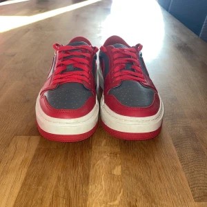 Nike Air Jordans i rött och grått - Säljer ett par snygga Nike Air Jordans i rött och grått. Skorna har en klassisk design med röd snörning och en vit sula. Perfekta för både vardag och fest! De är i bra skick och redo för nya äventyr. Har tyvärr inte kvar boxen.